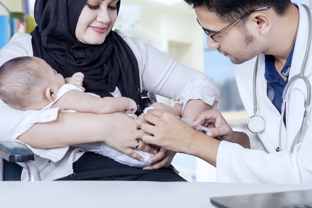 Pediatrician giving vaccine to baby boy