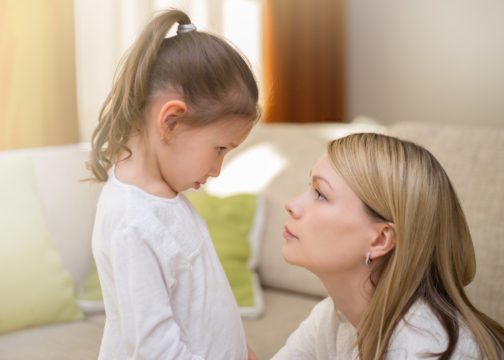 Beautiful mother is comforting her sad little daughter at home.