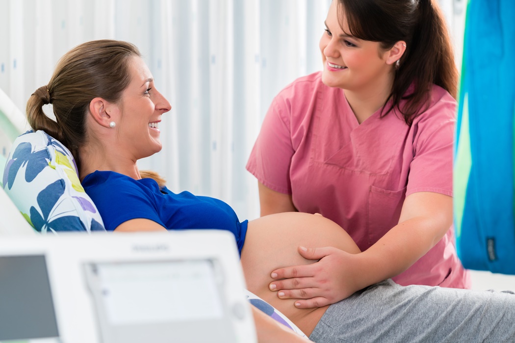 Pregnant woman in delivery room with CTG monitoring