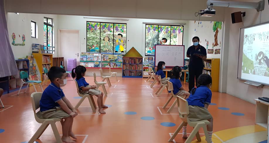 students in class practicing social distancing