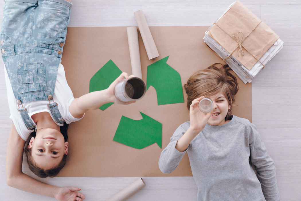 High angle of kids lying on paper during environmental protection classes at school
