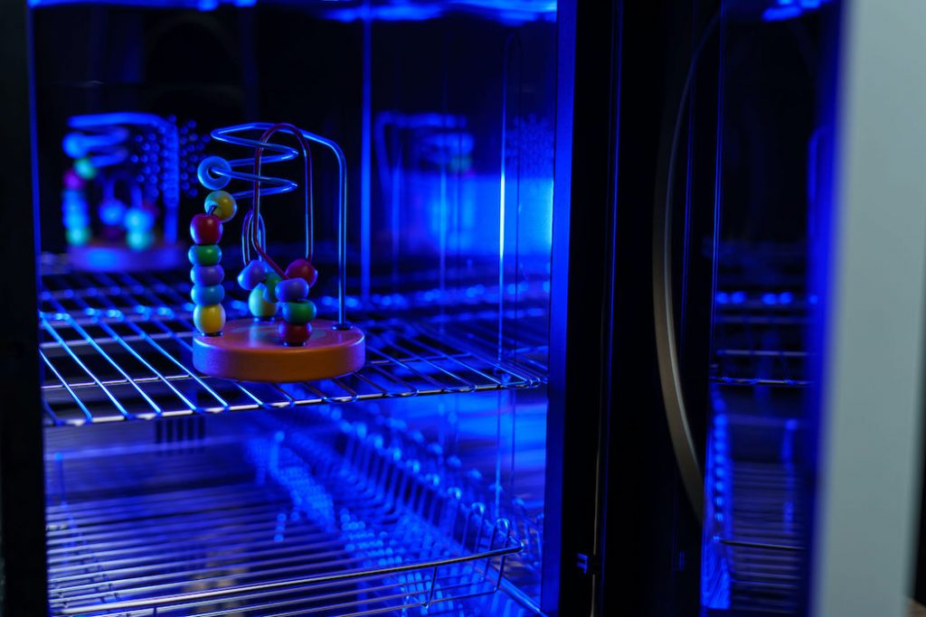 UV light sterilization of baby wooden toy to disinfection. COVID-19 prevention concept. ultra-violet sterilization and disinfection.