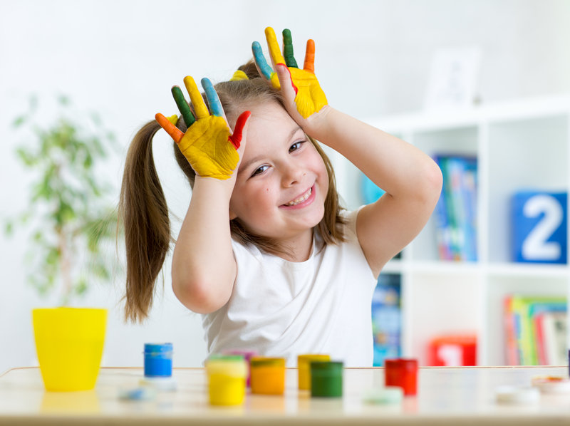Portrait of cute little girl with painted palms