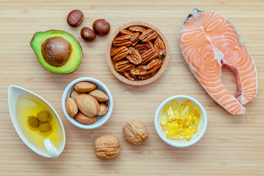 Selection food sources of omega 3 and unsaturated fats. Super food high omega 3 and unsaturated fats for healthy food. Almond ,pecan ,hazelnuts,walnuts ,olive oil ,fish oil ,salmon and avocado on wooden background .