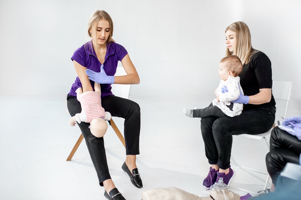 Young mother with baby during the first aid training