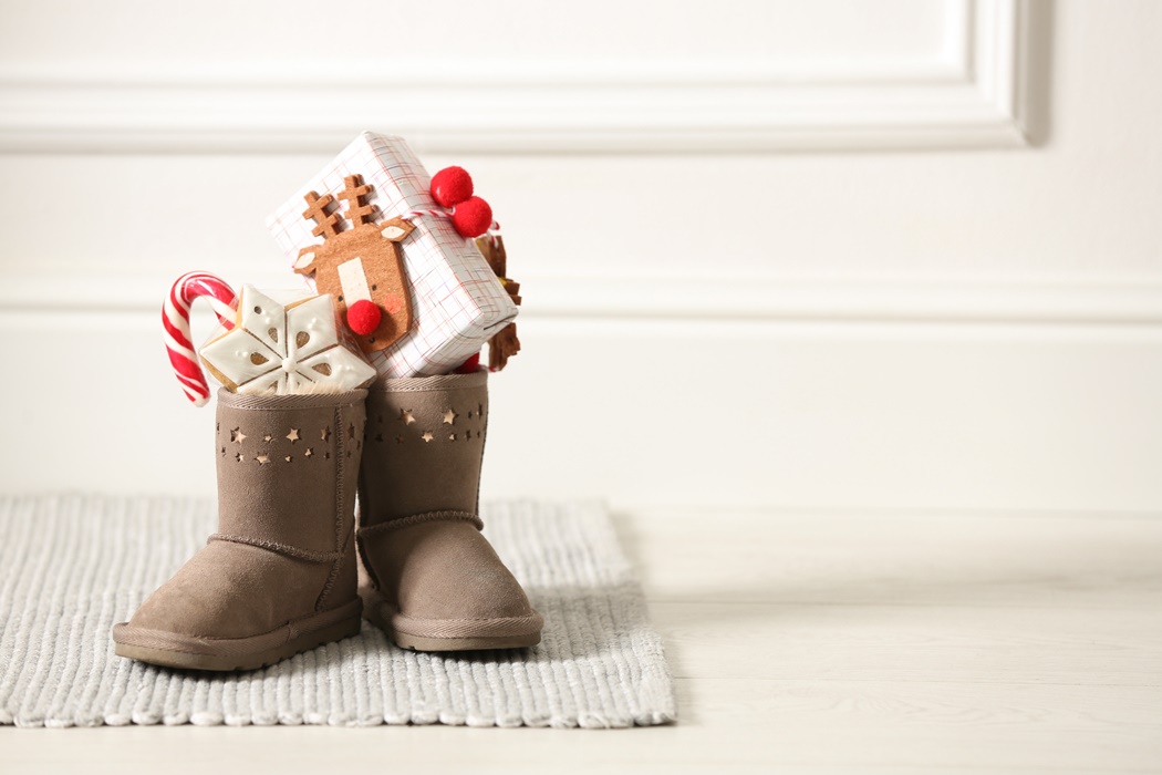Sweets and gift box in child's boots indoors, 
