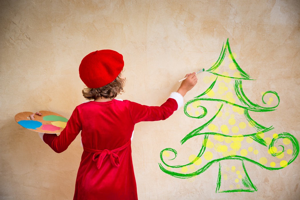 Child painting Christmas decorations
