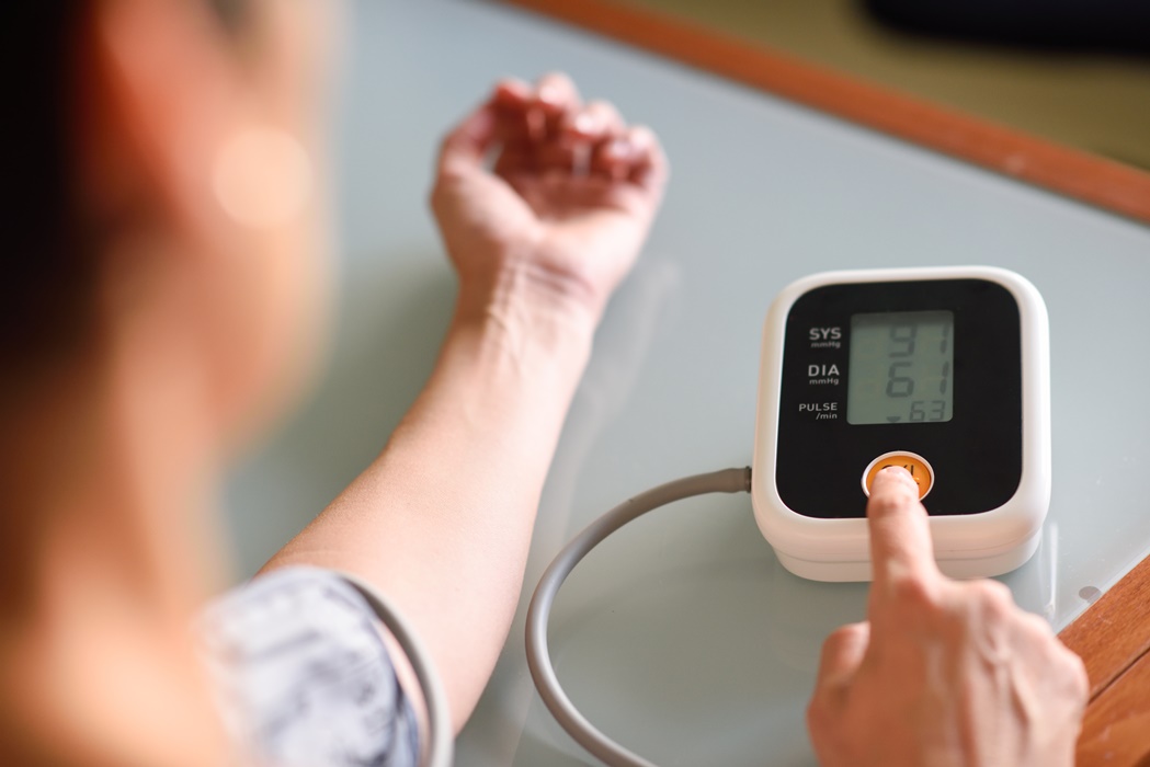 Woman measuring her own blood pressure at home.