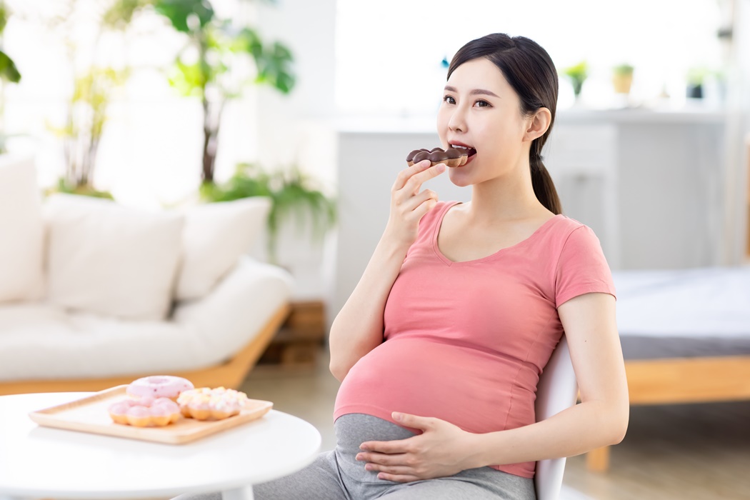 Asian pregnant woman eat donuts