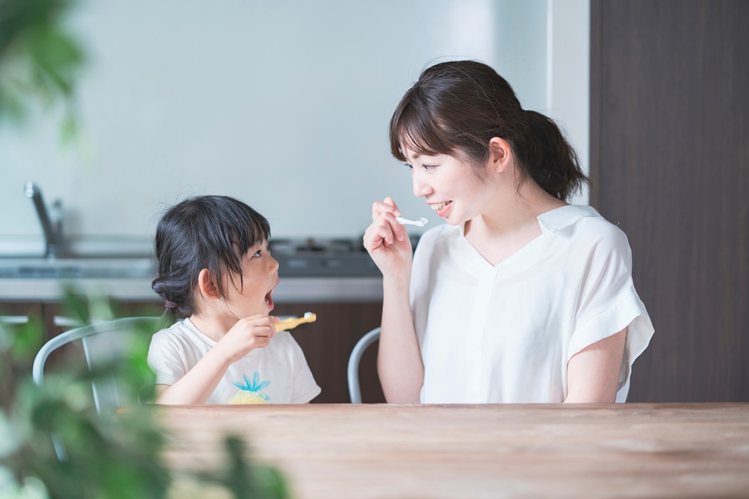 mom and daughter brushing teeth