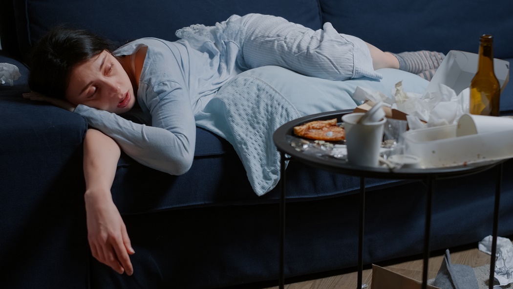 Depressed woman lying alone on sofa feeling tired vulnerable weak crying