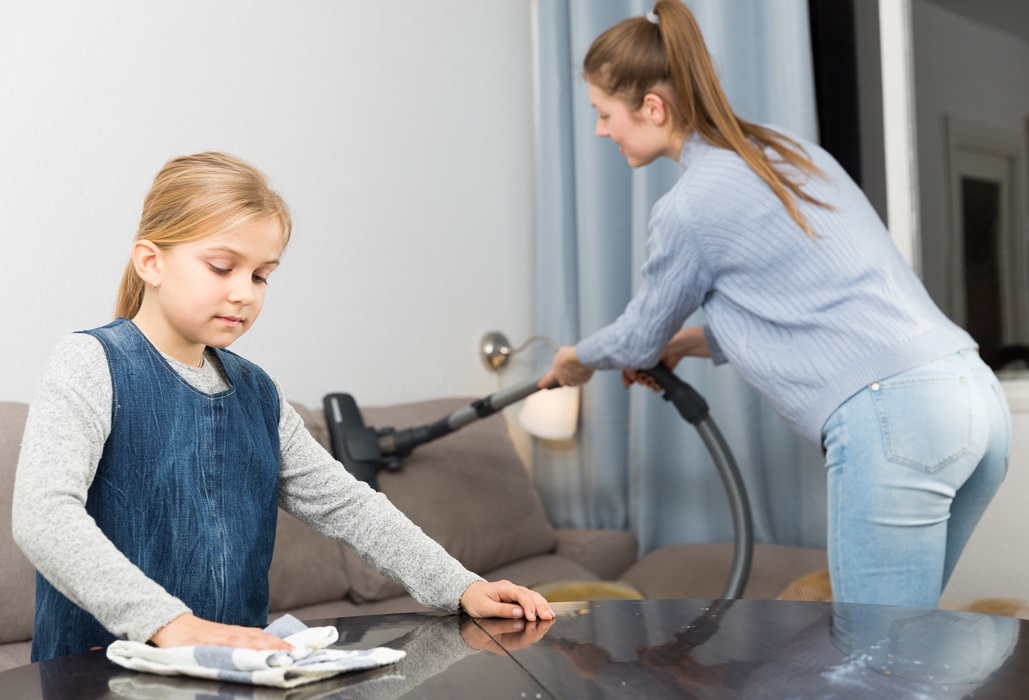 Girl helping mother with cleaning