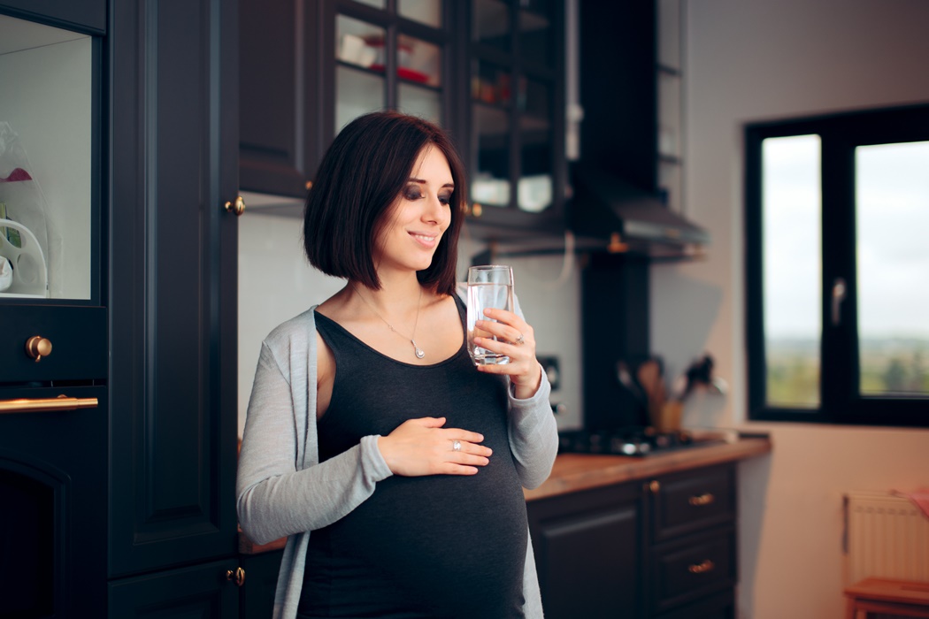 Pregnant Woman Drinking a Glass of Water for Healthy pregnancy